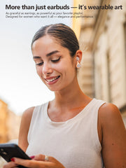 Woman wearing earbuds and earrings, holding a phone, with text about wearable art. earrings elegance and performance