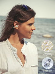 Woman wearing earrings with a scenic background, focusing on jewelry details.