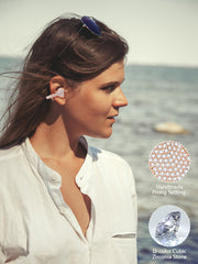Woman wearing earrings with a scenic background, focusing on jewelry details.